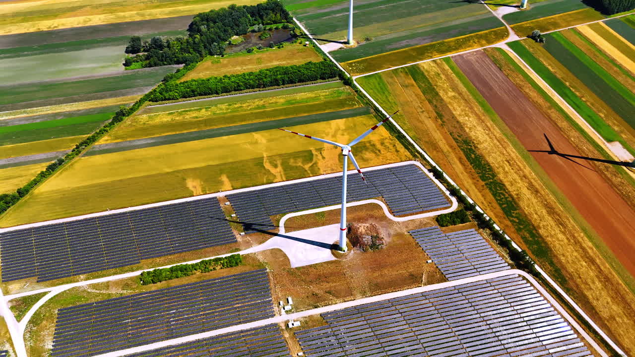 Production of sustainable energy from sunlight and wind. Aerial perspective on the wind turbine and solar panels site