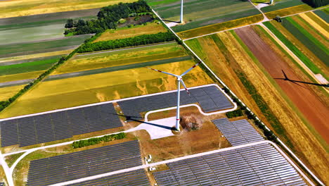 production of sustainable energy from sunlight and wind. aerial perspective on the wind turbine and solar panels site