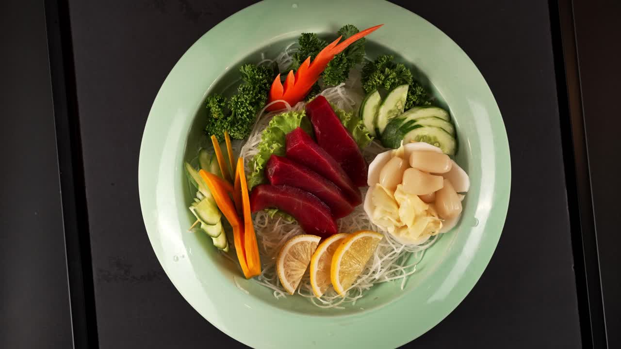 Fresh red fish sashimi paired with crisp vegetables, enhanced by ginger and lemon. 신선한 붉은 생선 사시미와 채소가 조화로운 한 접시. 생강과 레몬이 풍미를 더합니다.