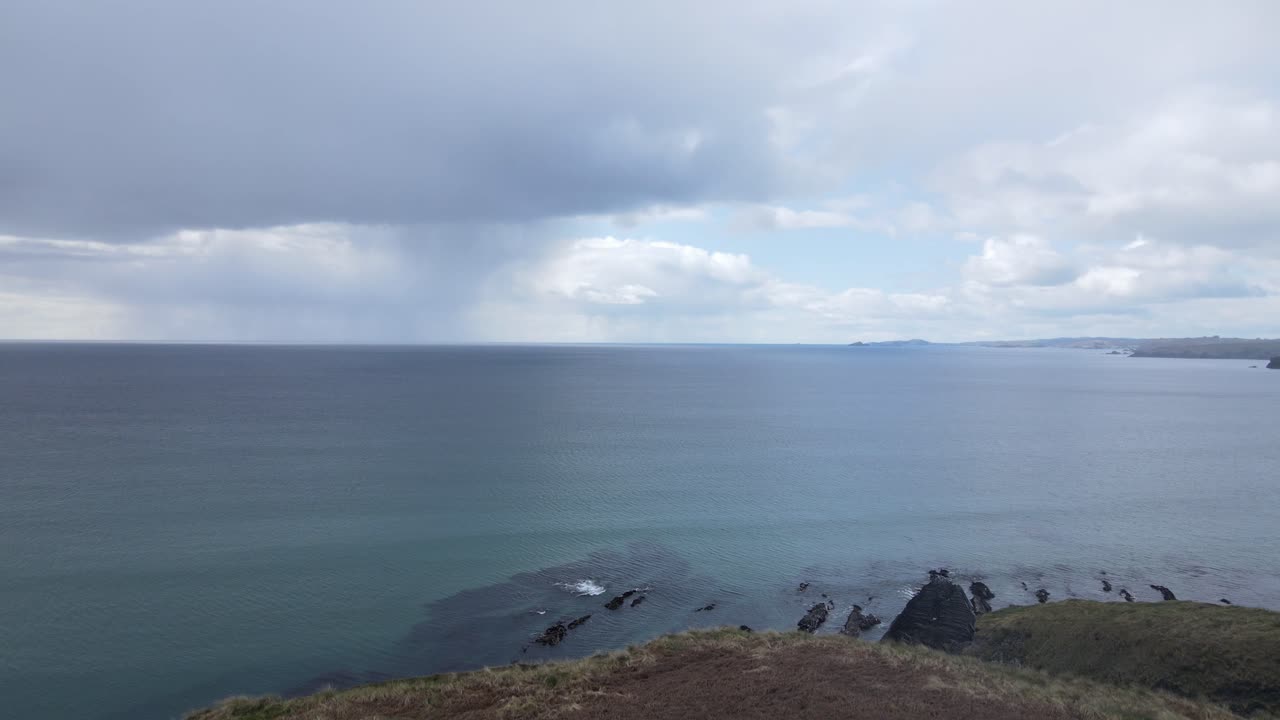 Lift-off from grass patch on the coastal West Cork, Ireland with the view on open calm Atlantic Ocean and distant rain