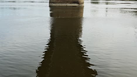 under the river bridge, tranquil surface of the water