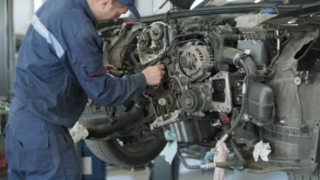 mechanic repairing car engine in auto workshop