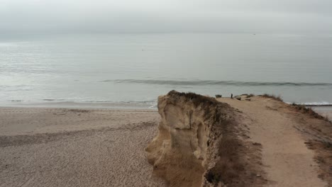 Tiro-De-Dron-Del-Acantilado-En-Santa-Cruz-Cerca-De-La-Caminata-De-La-Tabla-De-Playa-En-Un-Día-Nublado-Temprano-En-La-Mañana