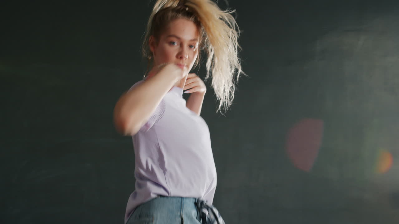 una mujer joven bailando en el estudio.