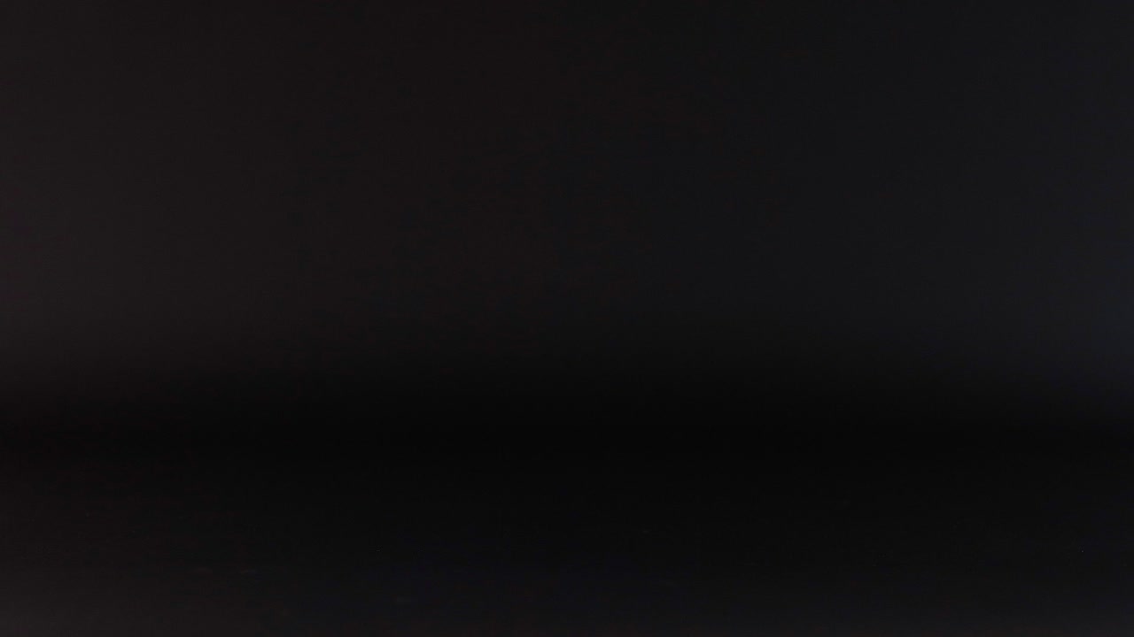 una pelota de tenis se mueve a través de un fondo oscuro