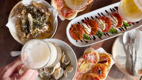 a vibrant beachside meal with beer, pizza, clams, and bruschetta under natural lighting in phuket, thailand