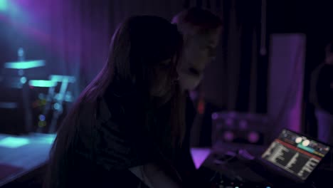dos hermosas mujeres jóvenes dj tocan la música en la consola de mezcla en el club nocturno