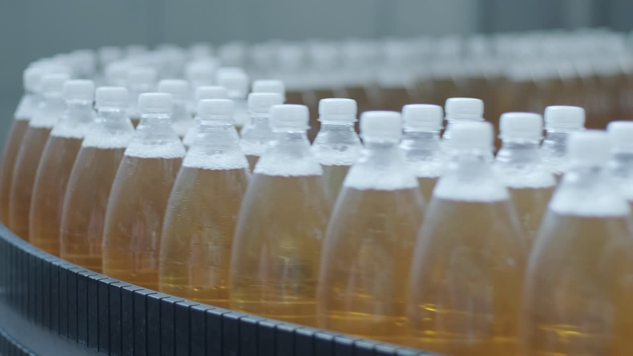 현대 음료 공장에서 주스 또는 물을위한 병을 가진 컨베이어 벨트 - 달한 소다 물의 현대 생산