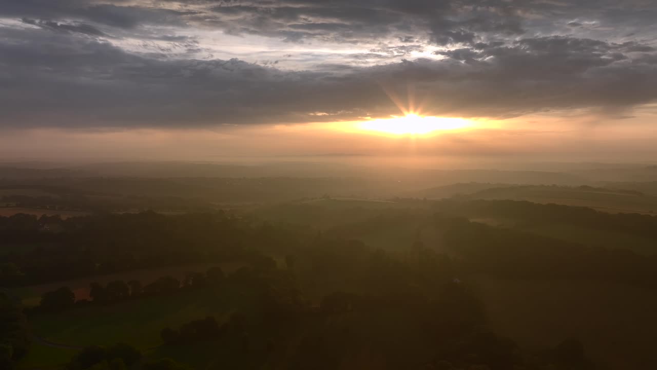 Misty rural sunrise over South West English countryside. Summer. Cornwall, UK.