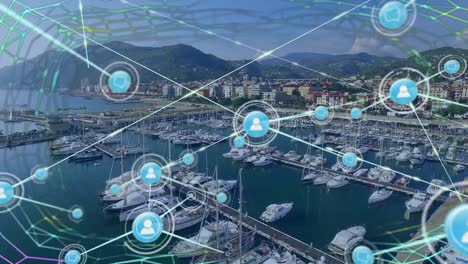animación de patrones abstractos e íconos conectados sobre una vista aérea de barcos estacionados en el muelle.