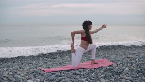 woman practicing yoga on a beach