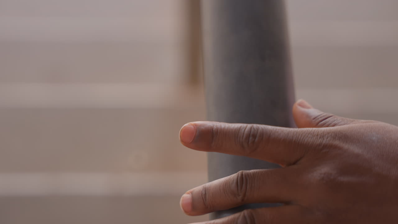 Closeup of hand gripping stair railing. Urban staircase safety with textured pole and grasping hand. Careful descent on city stairs showing textured support pole and secure hand grip