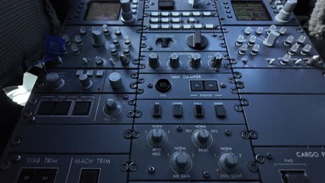 downward view of the flight controls and instruments of a modern jet cockpit in a real time flight, with the two pilots seated