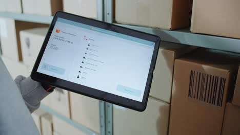 warehouse employee using tablet for package tracking and inventory management