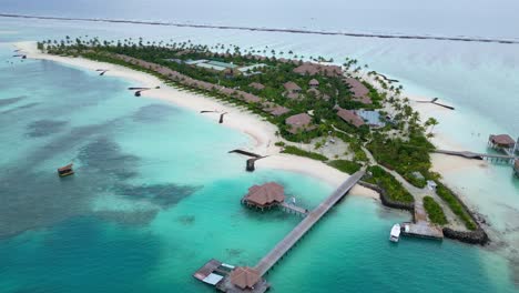 aerial top down of luxury island of maldives with mansions and villa resort on sunny day. paradise on earth. sandy beach with jetty in noble upper class hotel area.