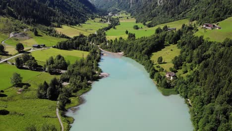 countryside landscape with calm lake water and lush vegetation in klammsee, kaprun, austria - aerial shot