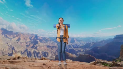 full body of asian female hiker with mountaineering backpack smiling, touching her chest, and pointing to camera while traveling at the top of mountain