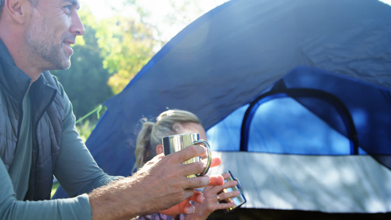 텐트 밖 에서 커피 를 마시는 가족