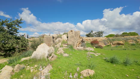 A-rocky-landscape-with-large-boulders-and-green-grass-at-the-Tombs-of-the-Kings-in-Pafos