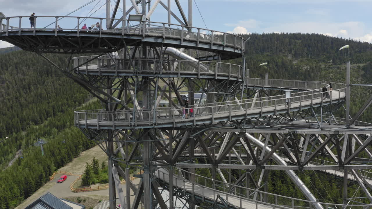 toma giratoria de 4k de personas caminando por el cielo caminando en dolní morava, república checa con montañas y bosques en el fondo