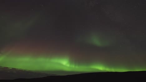 The-dark-still-waters-of-the-fjord-are-illuminated-by-the-beautiful-dance-of-the-Aurora-Borealis-in-the-winter-sky