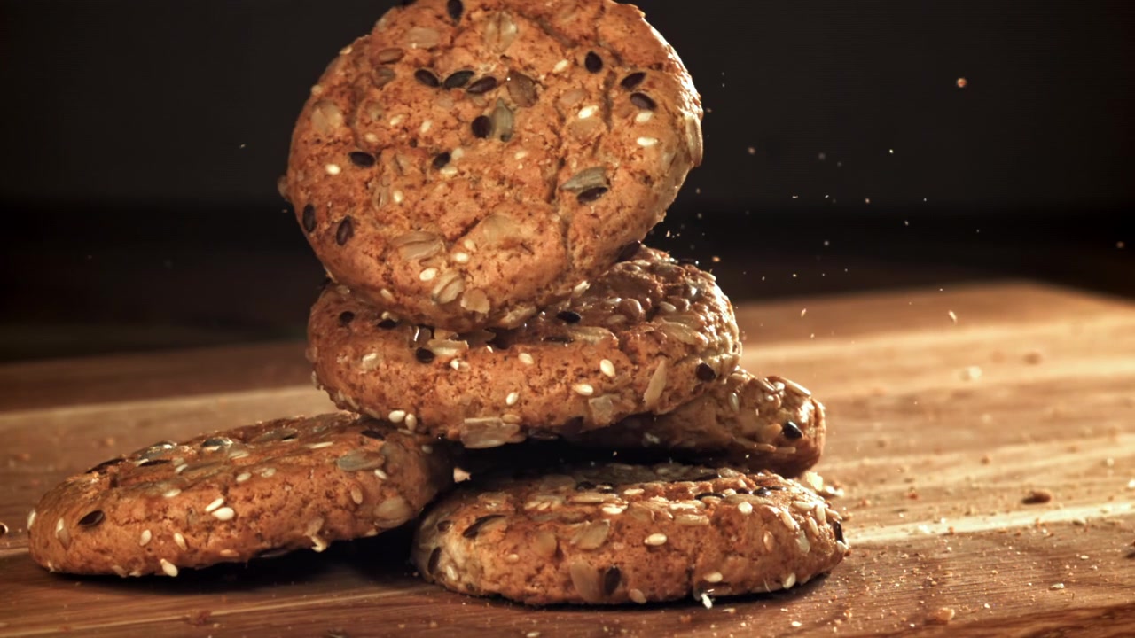 Slow Motion of Seed Cookies Falling and Stacking on a Wooden Table