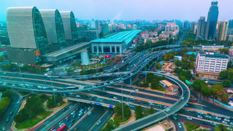 Vogelperspektive-Bei-Nacht-Mit-Hellem-Stadtblick-Auf-Mehrstöckige-Kreuzungsstraßen-Mit-Fahrenden-Autos,-Verkehr-Auf-Einer-Modernen-Autobahn-Mit-Überführungsbrücke-Auf-Dem-Land-In-Der-Nähe-Von-Bootsströmen-Im-Fluss