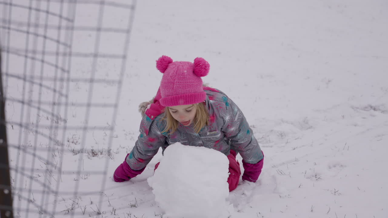 귀여운 소녀가 눈덩이에서 물린 것을 슬로우 모션으로 가져갑니다.