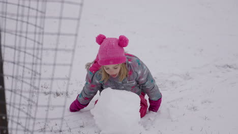 cute little girl takes a bite out of a snowball, slow motion