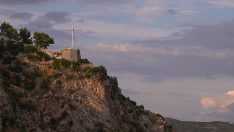 Atemberaubender-Blick-Auf-Den-Sonnenuntergang-Der-Albanischen-Flagge-Auf-Dem-Turm-Der-Burg-Berat