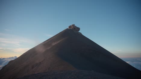 La-Tranquila-Mañana-Del-Volcán-Fuego-Entra-En-Erupción-Con-Una-Impresionante-Luz-De-Hora-Dorada,-Nubes-De-Ceniza-Llenan-El-Cielo