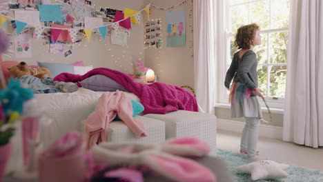 happy little girl playing with hula hoop in bedroom having fun at home on weekend