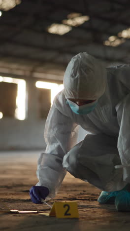 forensics investigator in a hazmat suit collecting evidence at a crime scene