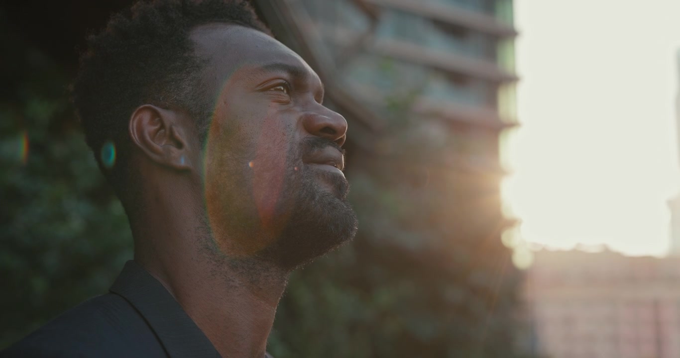 Homem Afro-Americano Pensativo Olhando para Cima ao Pôr do Sol