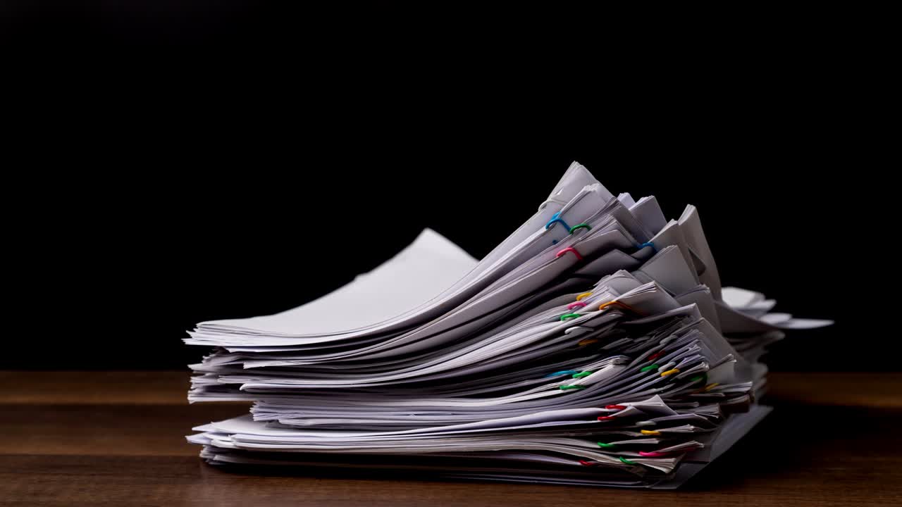 papel de informe de documento de sobrecarga de pila de movimiento de 4k con clips de papel coloridos en fondo negro y espacio de copia, imágenes de concepto de negocio sin papel utilizadas.