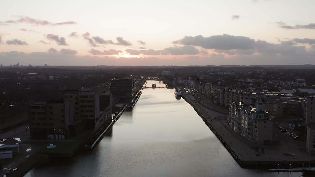 Drone flying backwards over a man made canal through a historical city