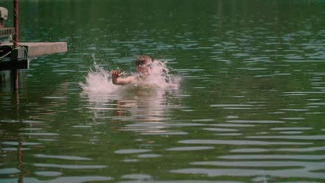 Süßer-Kleiner-Junge-Mit-Badebekleidung-Springt-Vom-Holzsteg-Ins-Wasser