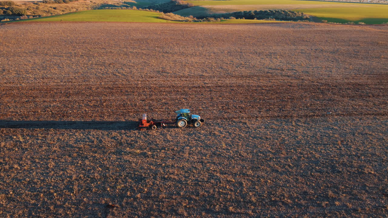 tractor arando un campo al atardecer