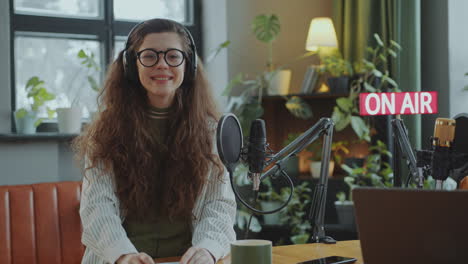 portrait of happy young girl in podcast recording studio