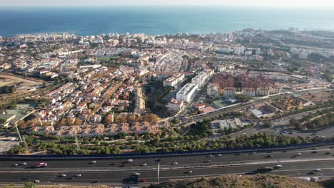 Busy-highway-of-Fuengirola,-panoramic-city-scape-with-buildings-and-sea-in-background