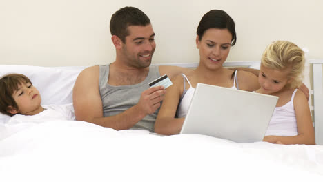 Familia-En-La-Cama-Comprando-Online