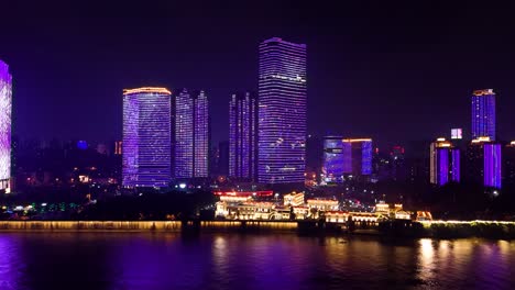 panorama view of neon purple skyscraper skyline and river lighting at night