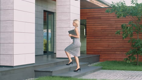 beautiful woman entering business office with laptop. female boss arriving work