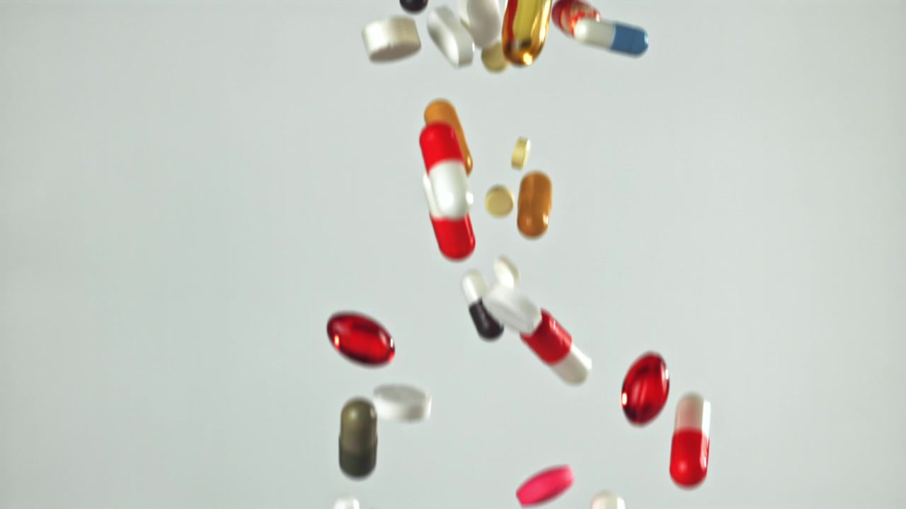 Colorful Pills and Capsules Falling in Slow Motion