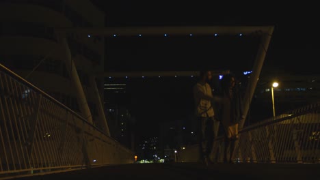 couple walking together hand in hand on a bridge 4k