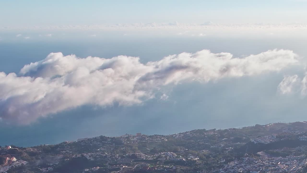 View of Malaga from high above with clouds and the sea
