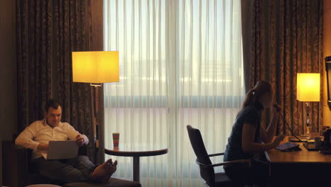 Young-man-and-woman-working-in-hotel-room