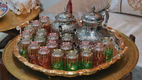 traditional moroccan tea set with a silver teapot, displayed on a decorative tray