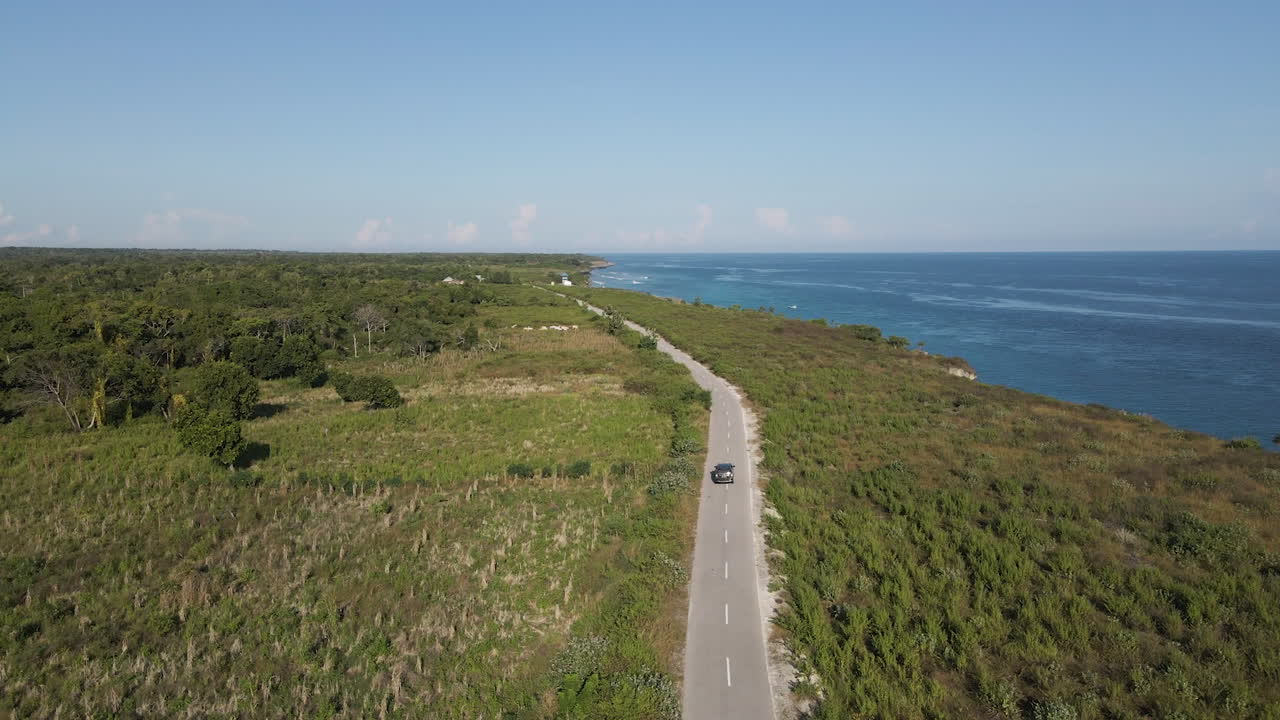 conducción de automóviles en la carretera con vistas al mar azul durante el día en verano en la isla de sumba, indonesia