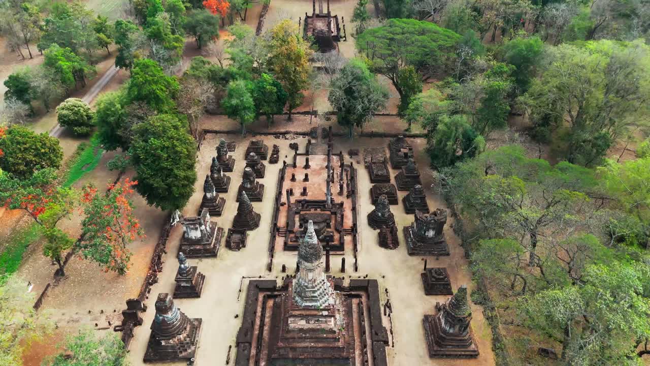 bird’s-eye view of Si Satchanalai Historical Park, moving above the ancient ruins. This aerial shot showcases the detailed layout and historical beauty of the park's archaeological site
